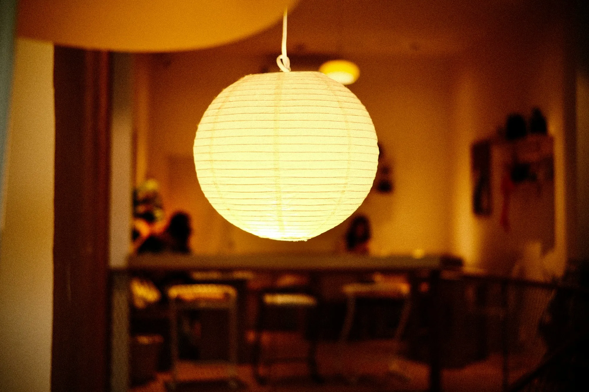 Paper lantern glowing over a dining table