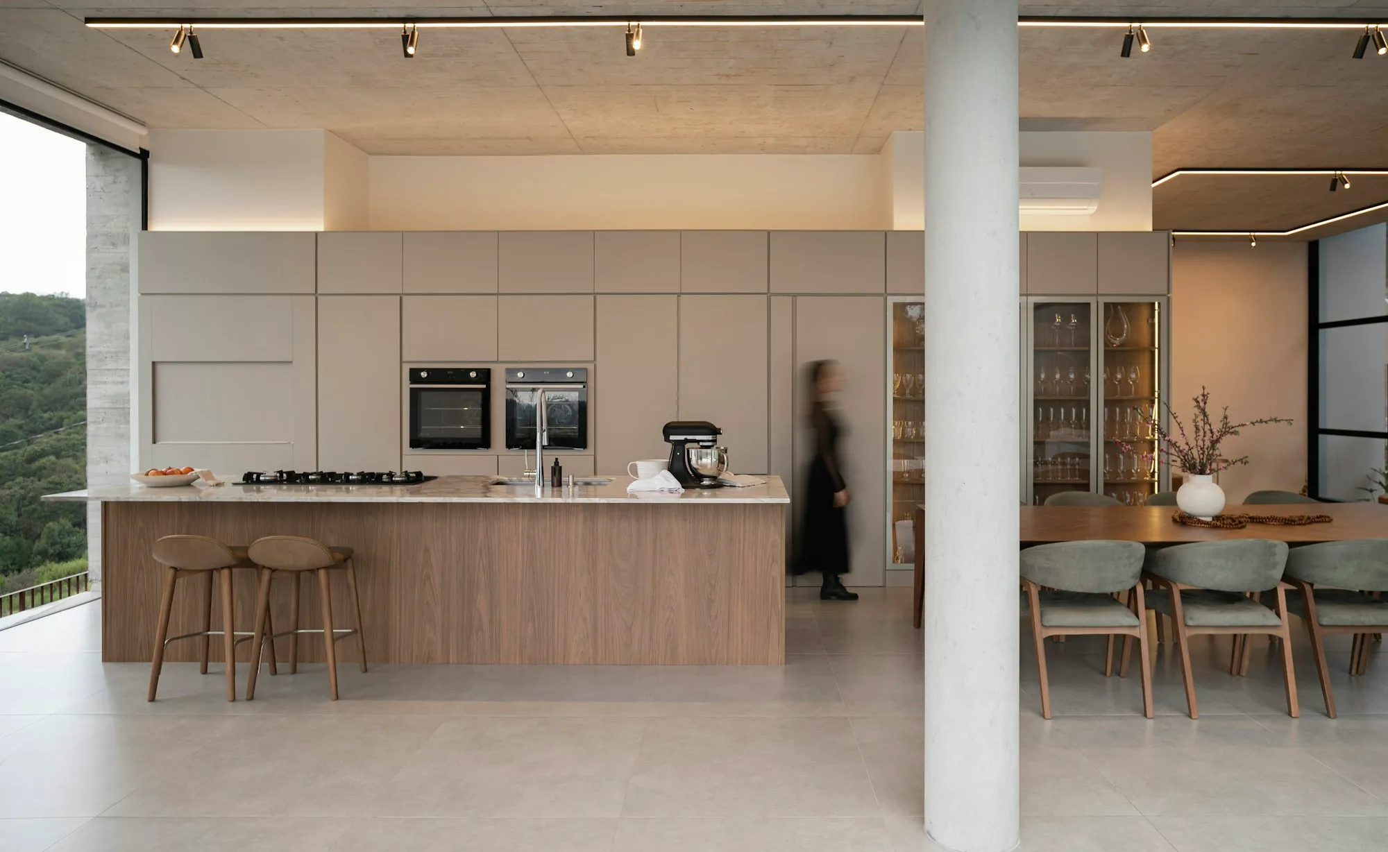Open-plan kitchen and dining space with concrete ceiling and garden views