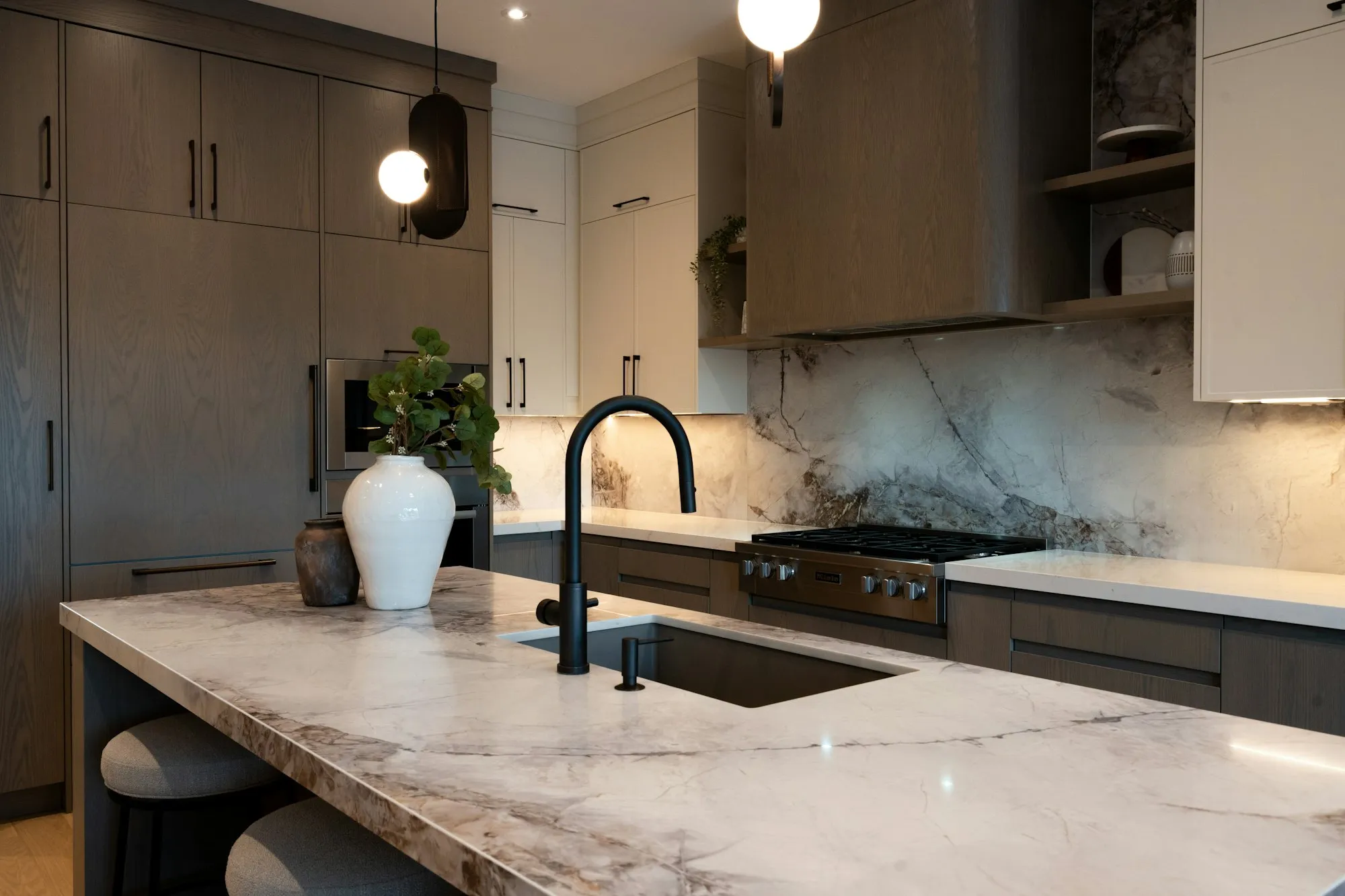 Kitchen with stone backsplash and walnut cabinetry